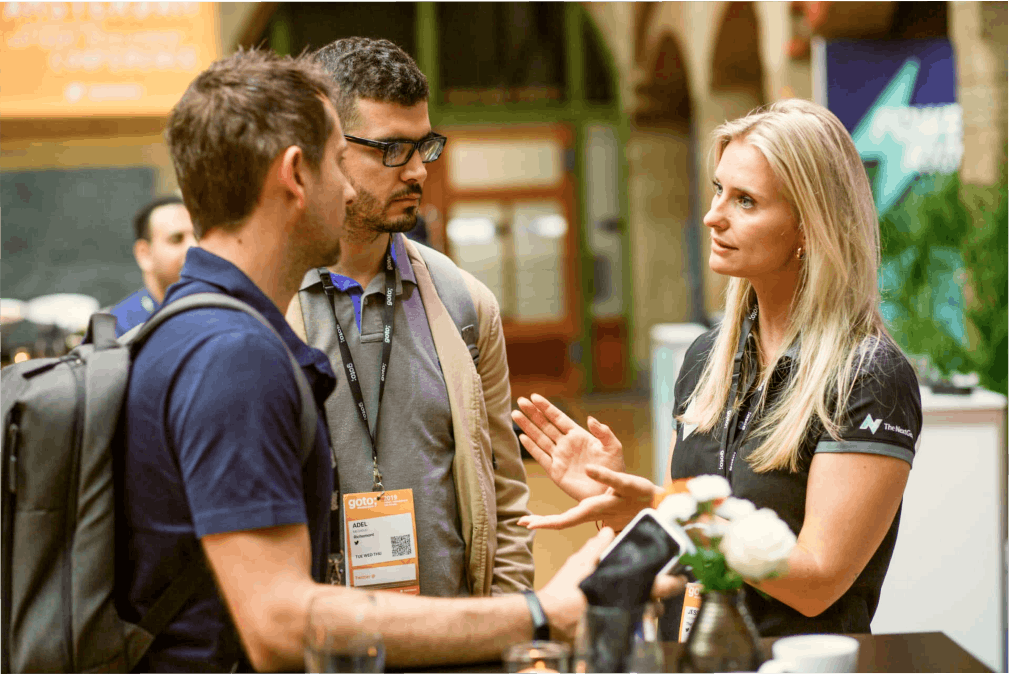 Twee IT-professionals praten met een NextGenner tijdens een event.