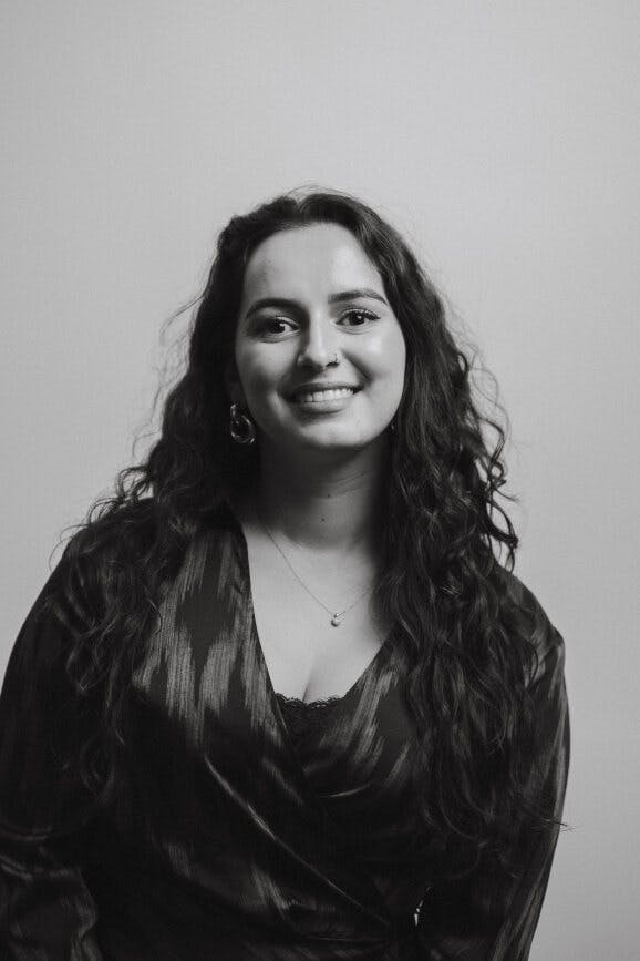 Tara kijkt in de camera en lacht.