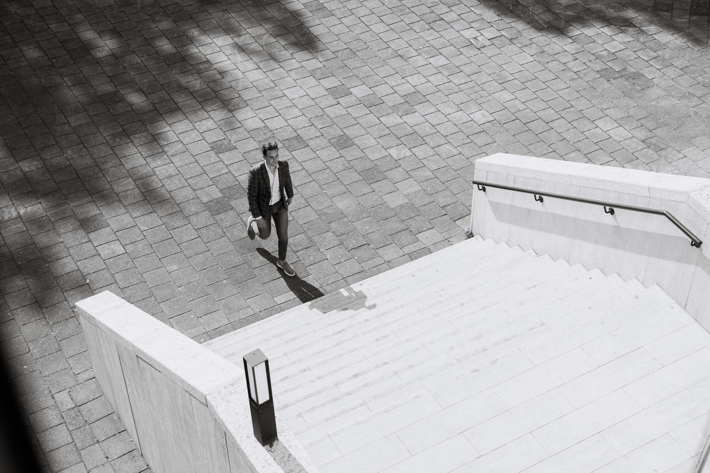 Een man loopt naar de eerste trede van de trap naar het kantoor van Elevation Group in Amsterdam.