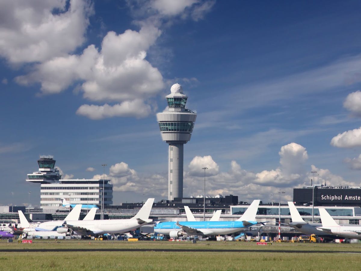 Schiphol toren en geparkeerde vliegtuigen eronder.
