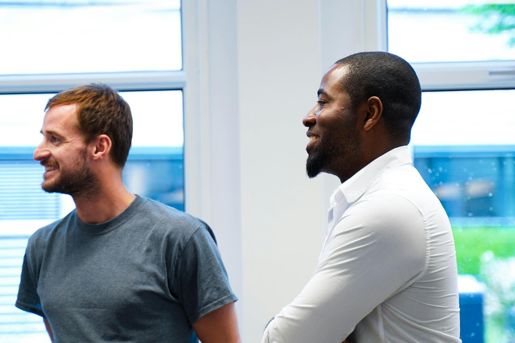 Lachende NextGenner Dja naast een andere it-specialist.