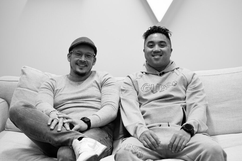 NextGenners Geoffrey en Richard zitten naast elkaar op de bank op het kantoor van The.NextGen