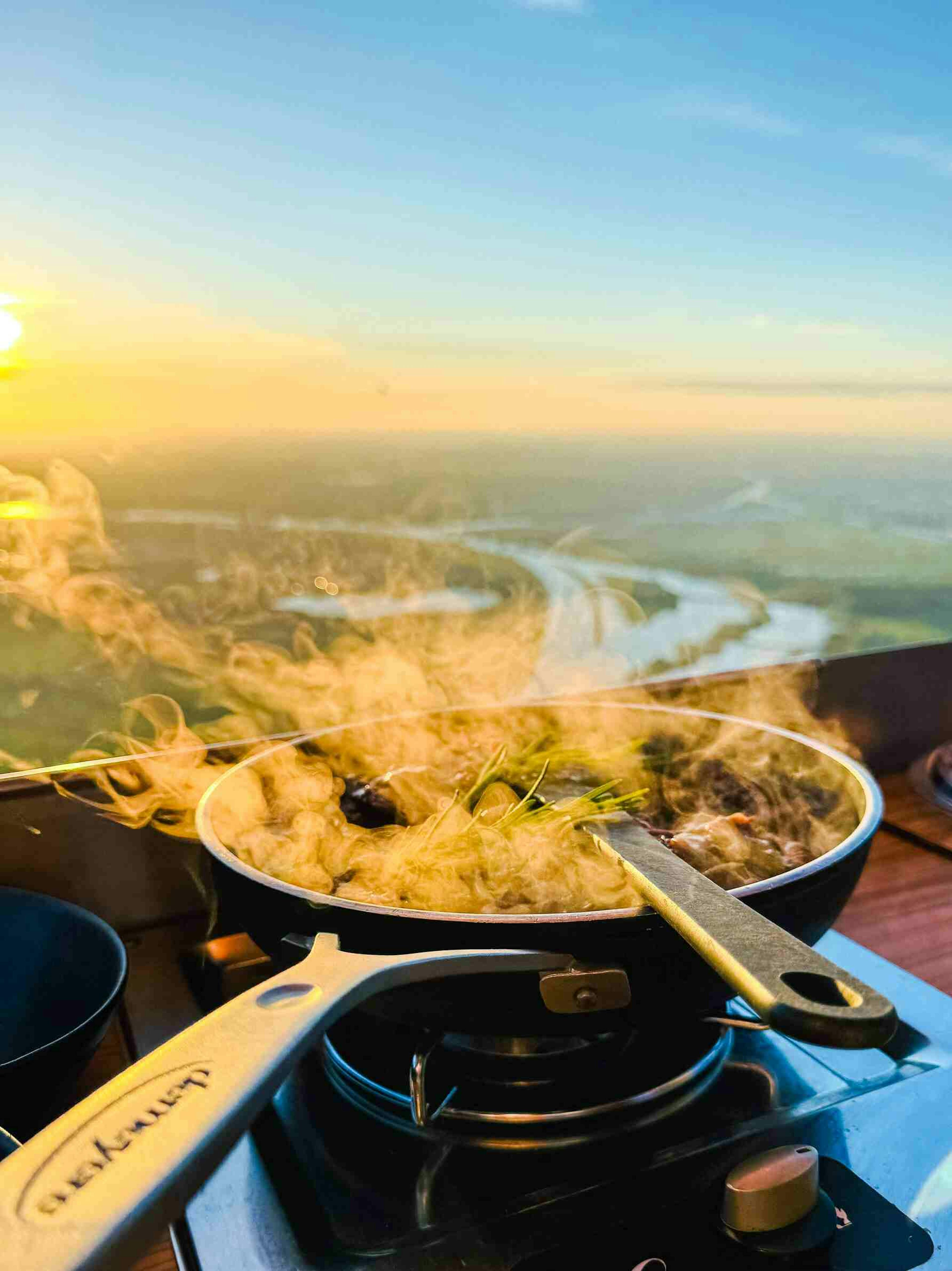 Op het fornuis in een luchtballon staat een koekenpan waar het eten in geflambeerd wordt. 