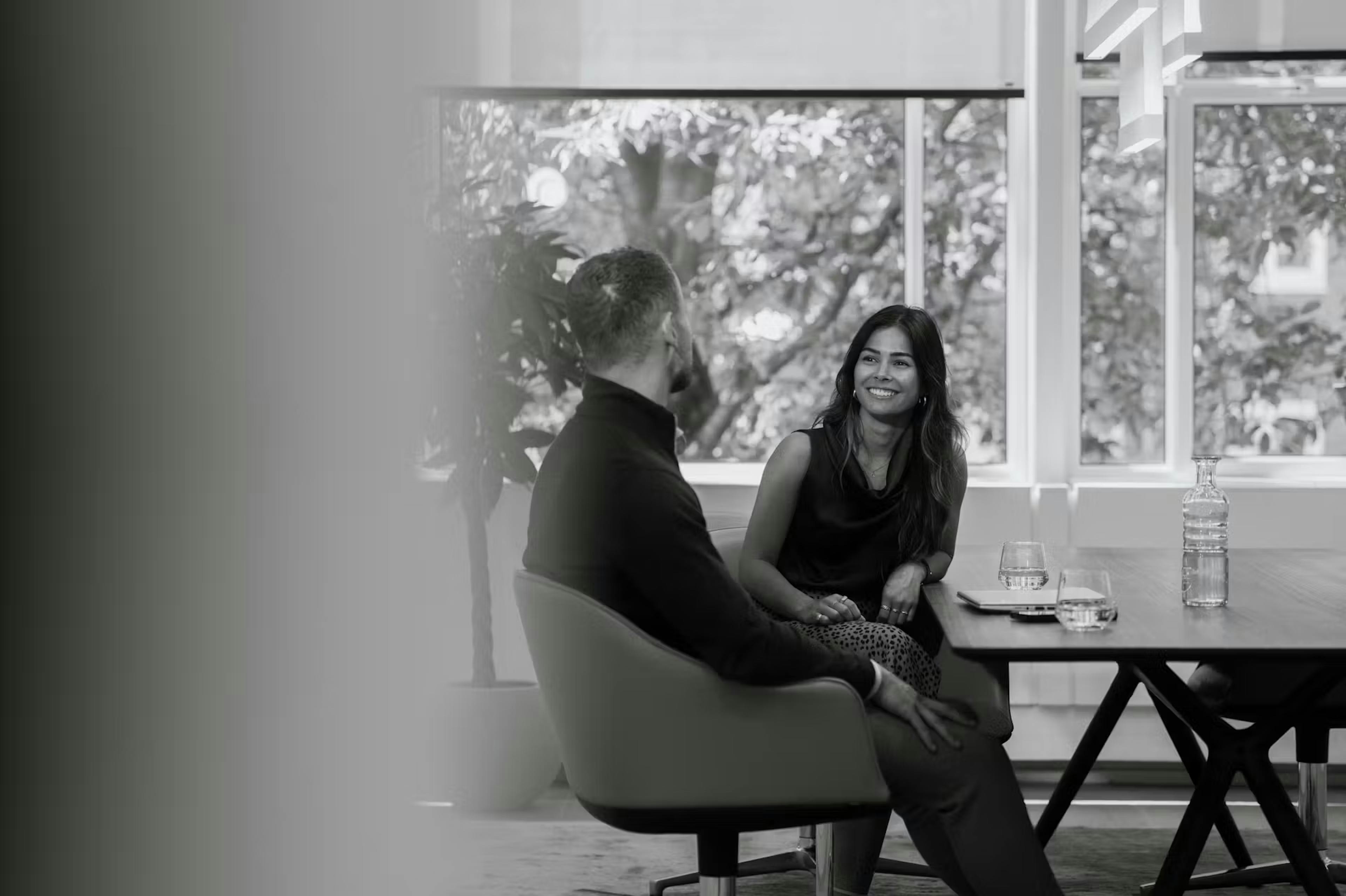 Zwart wit afbeelding van werknemers in gesprek.