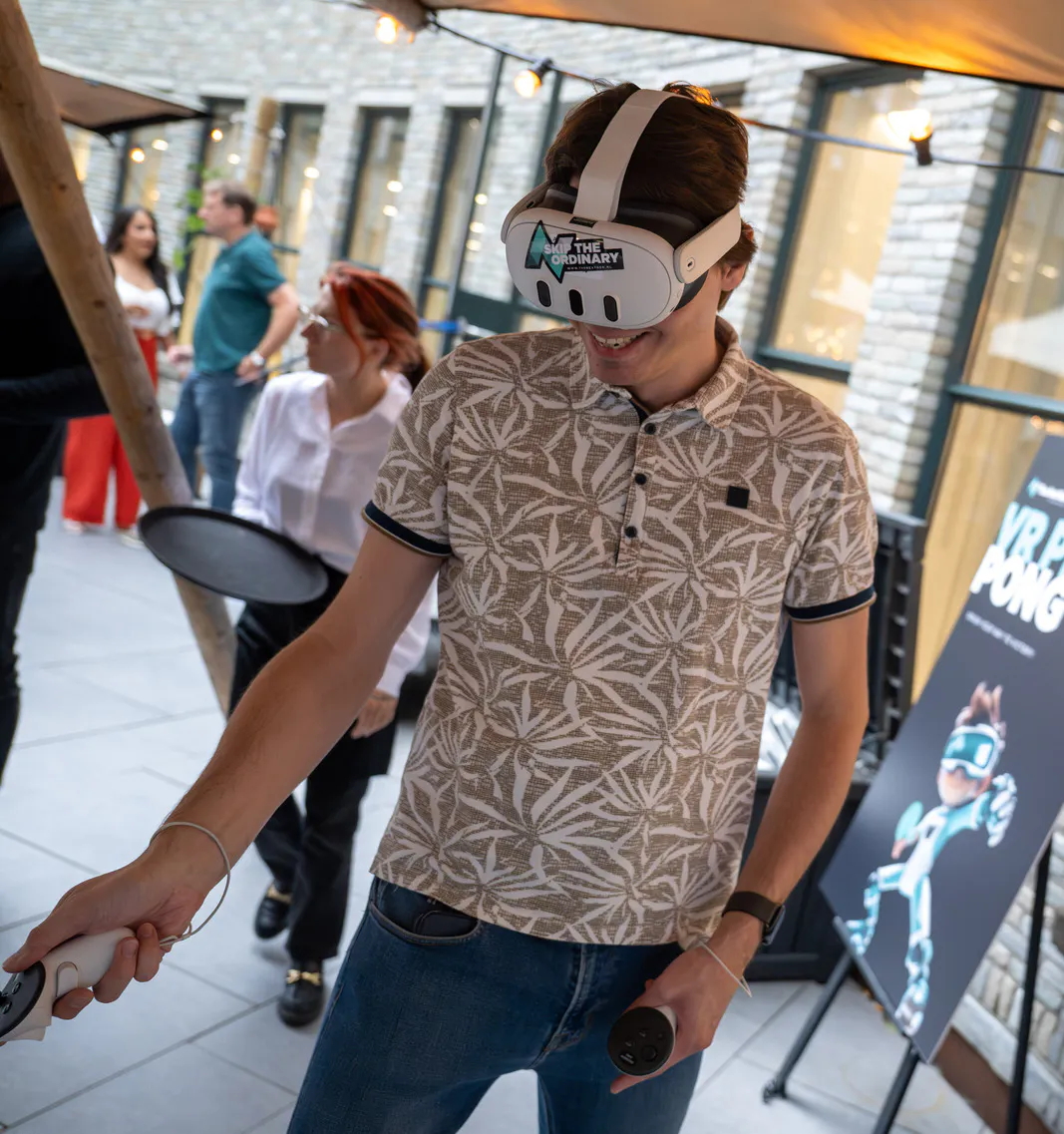 NextGenner staat lachend met VR bril op tijdens het The.NextGen Summer Event 2024.