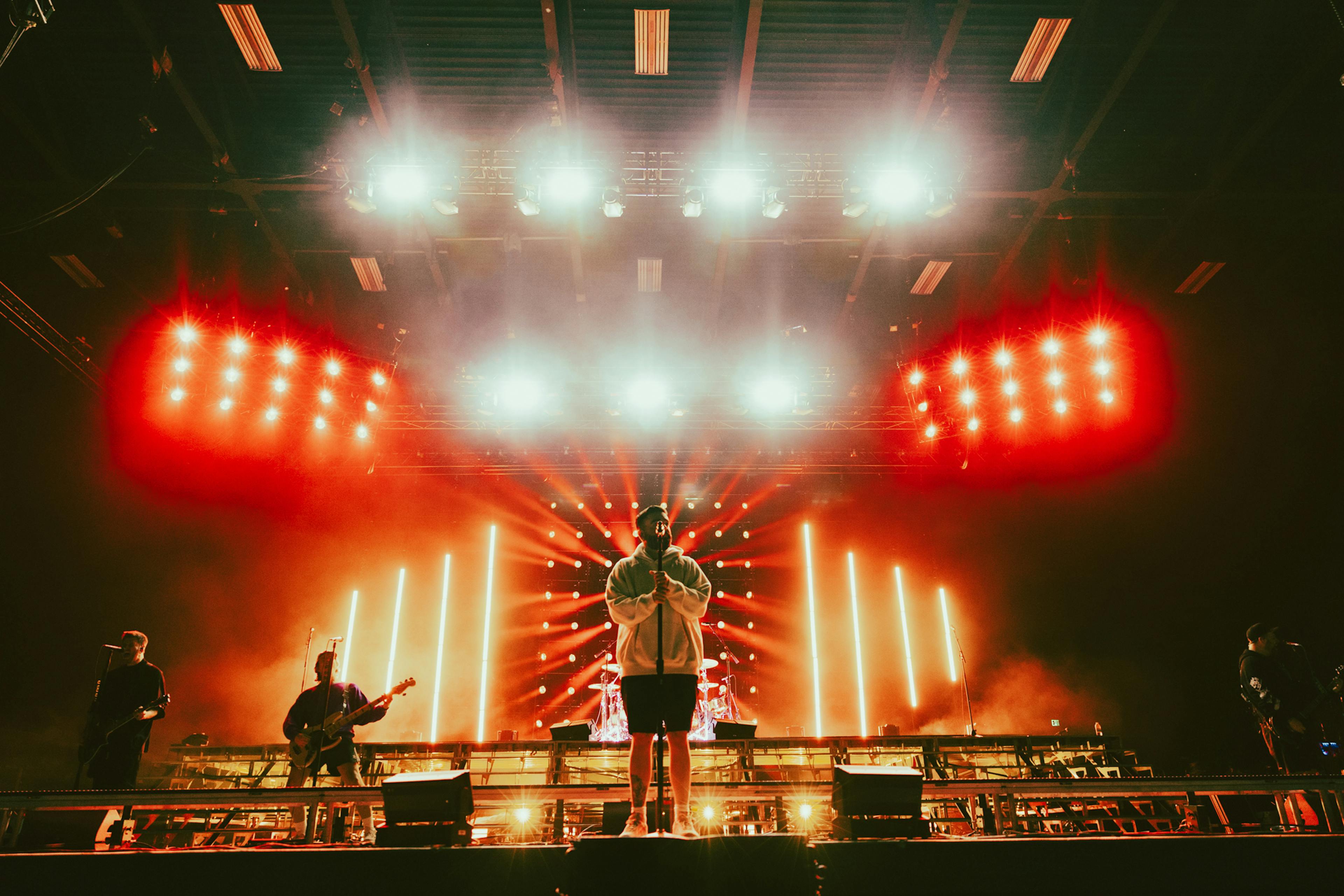 The band performs in front of a backdrop of lighting and staging.