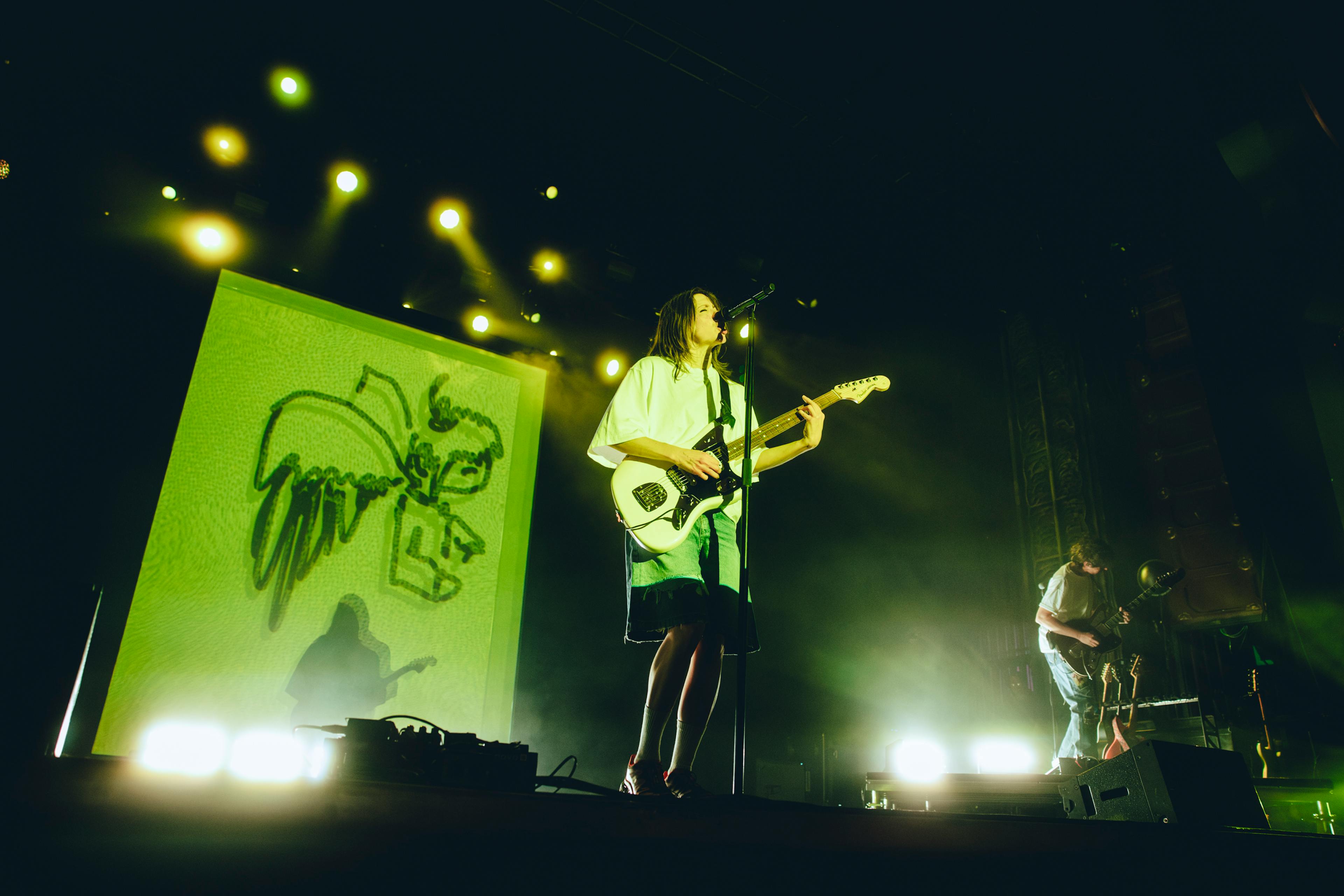 As projections split and shadows double, K.Flay performs alongside her own absence.