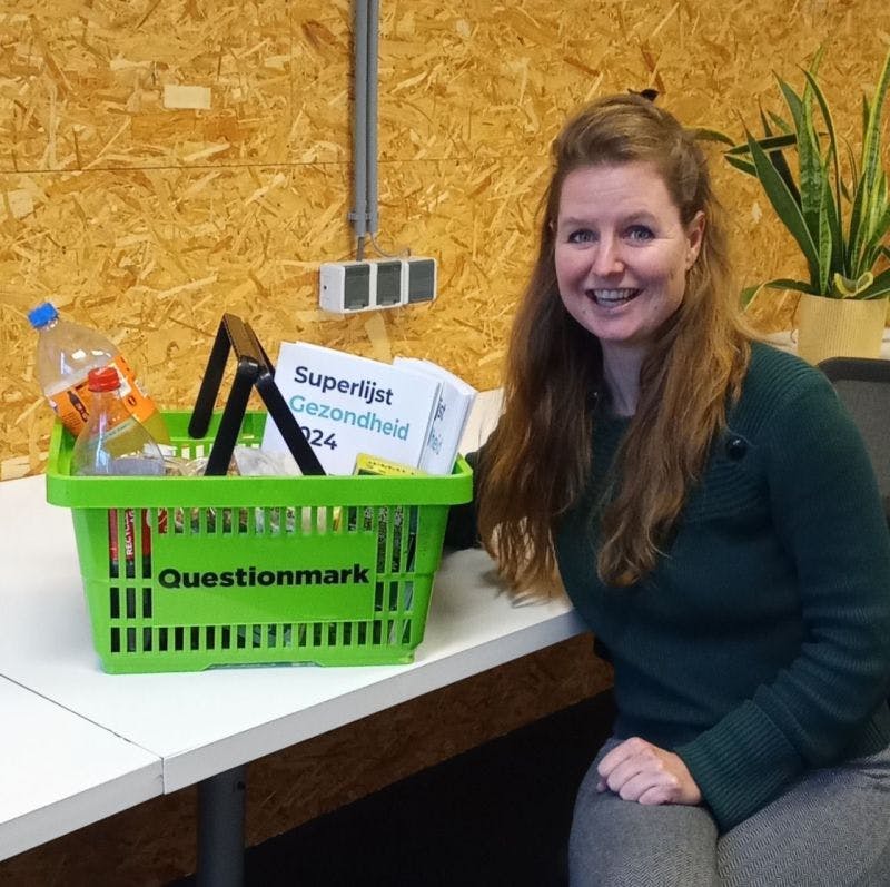 Lara Ribbing sitting at table with a shopping basket filled with Superlist reports