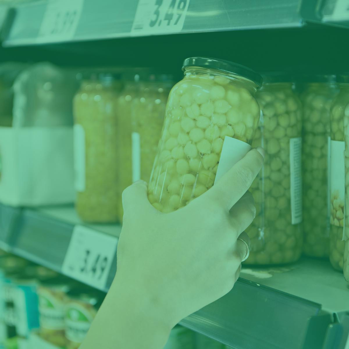 Hand grabbing can of chickpeas off a supermarket shelf