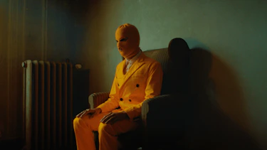 A yellow man sitting in a sofa