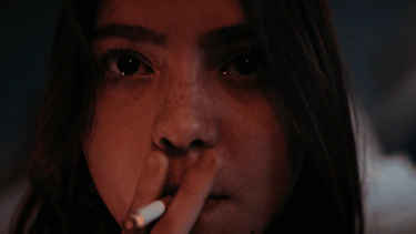 A big plan on a women face smoking a cigarette.