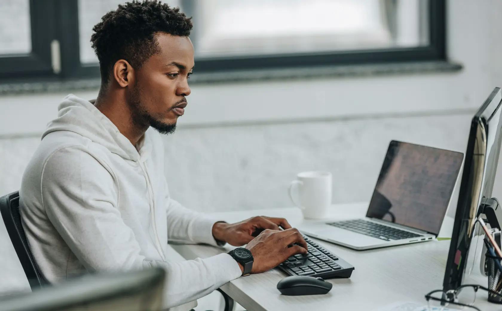 Man sitting at a desk typing on a computer