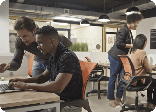 Image of people working together at work on a laptop