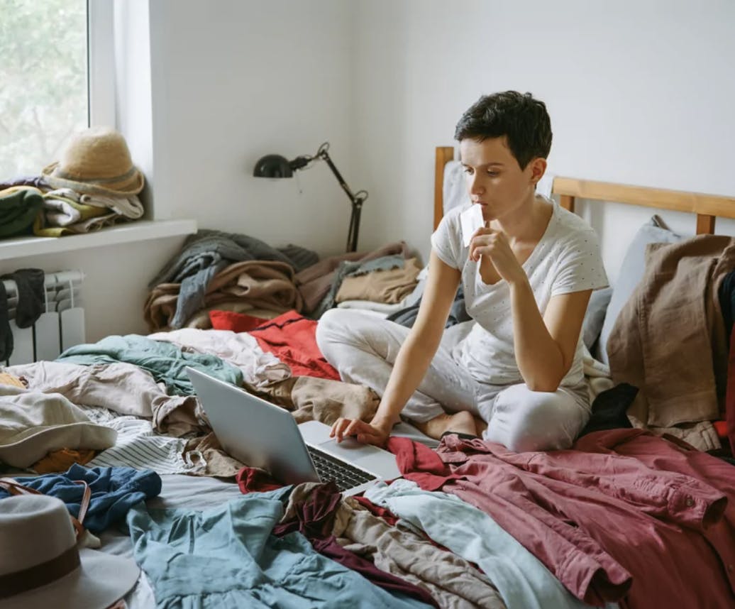 Woman on bed staring at laptop intensely