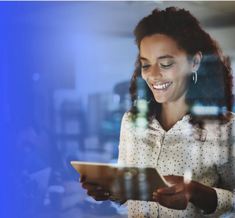 Woman staring at a tablet smiling