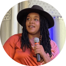 April Terry holding a microphone speaking to an audience