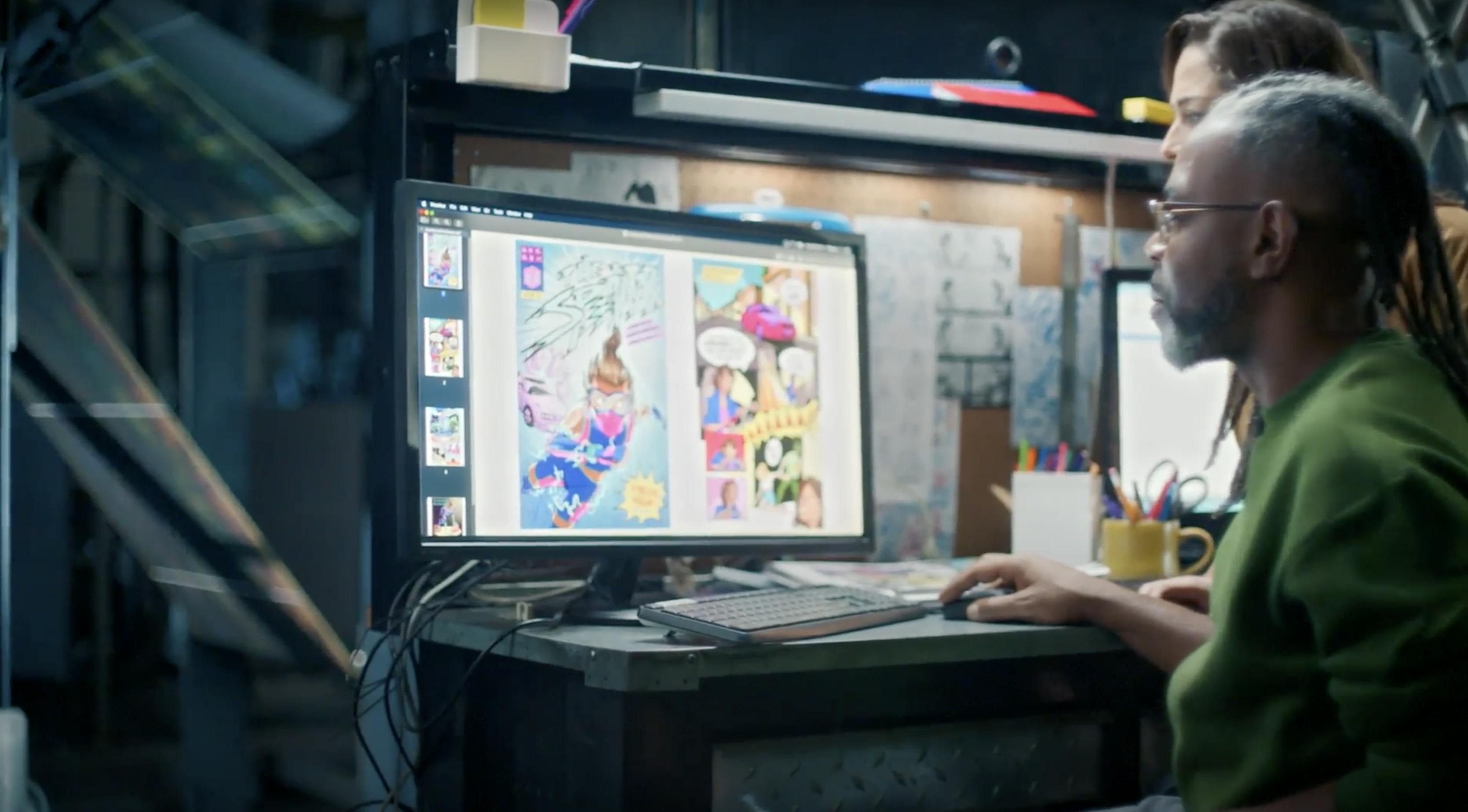 A man with looks at a computer screen with colorful images