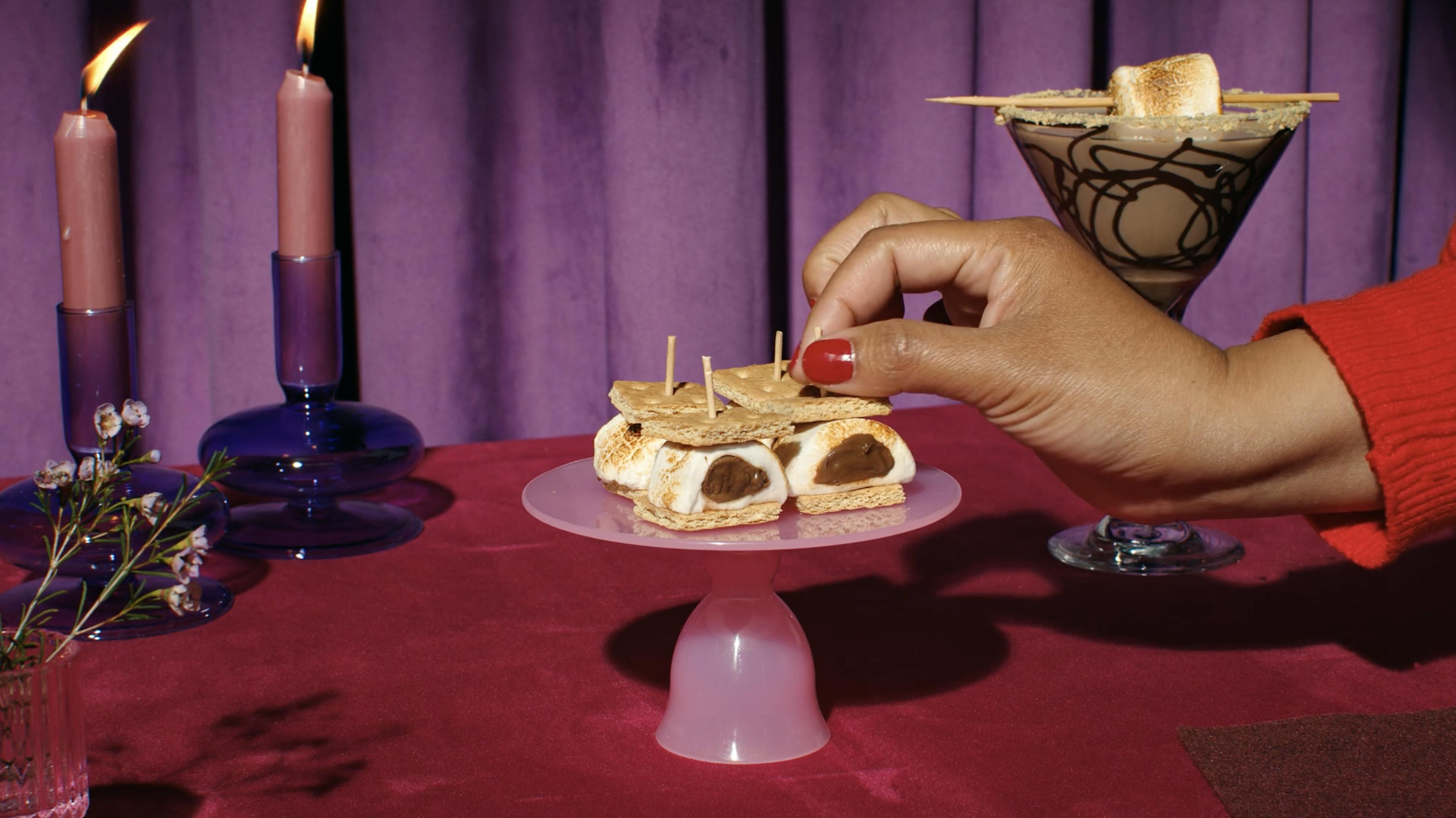 A cake plate of Stuffed Puff smores with a chocolate marshmallow martini in the background