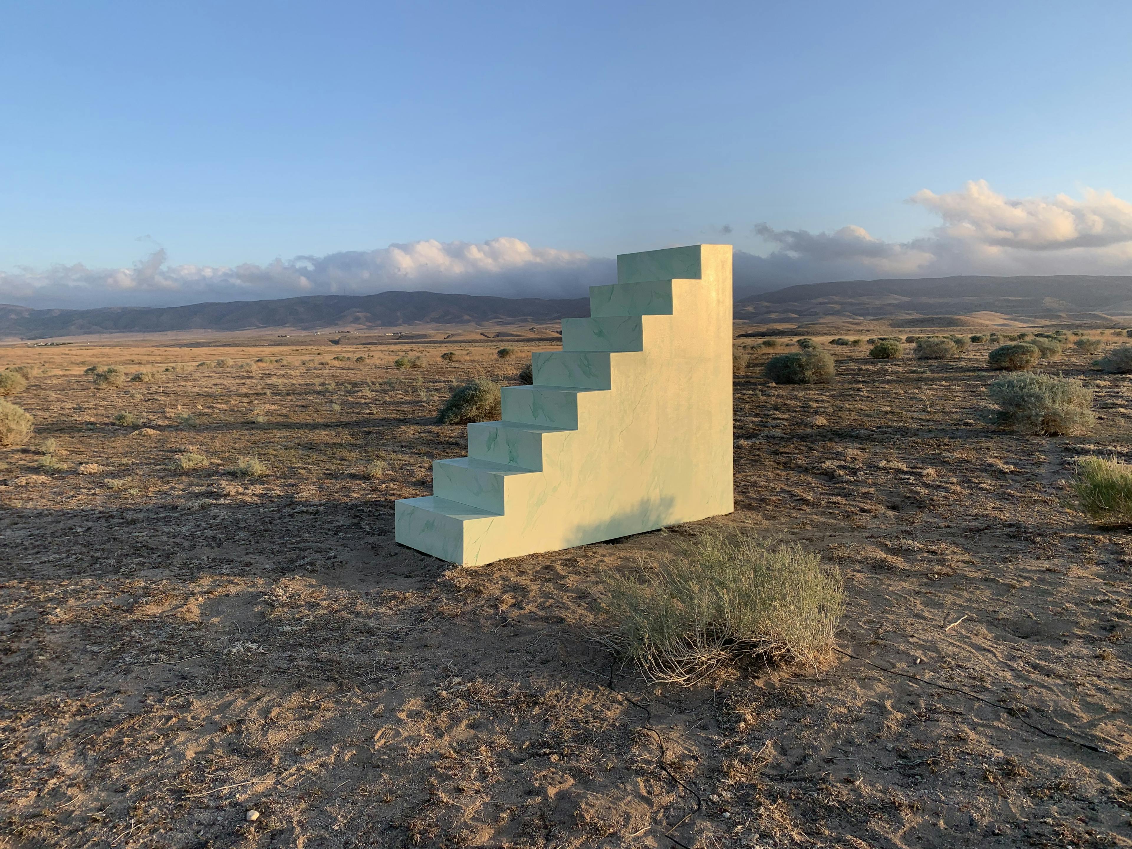 A concrete staircase sits in the desert
