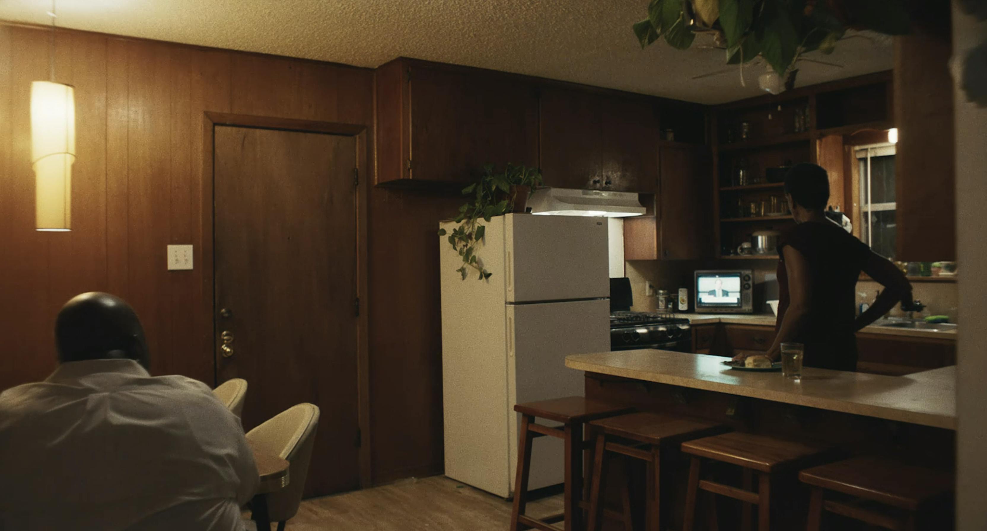 A kitchen with wood paneling and an old refrigerator