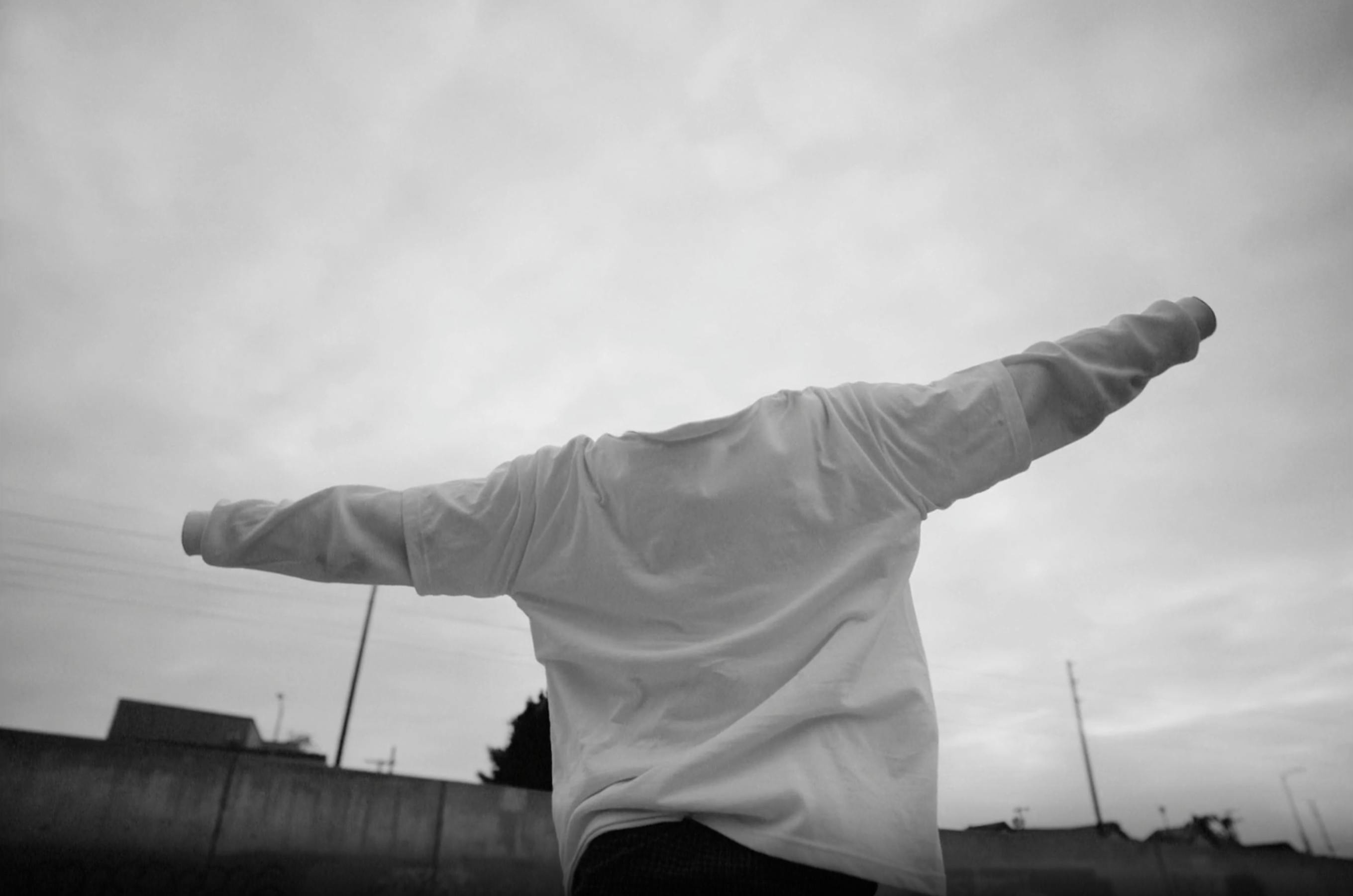A black and white image of a person with their arms outstretched, but the person is invisible