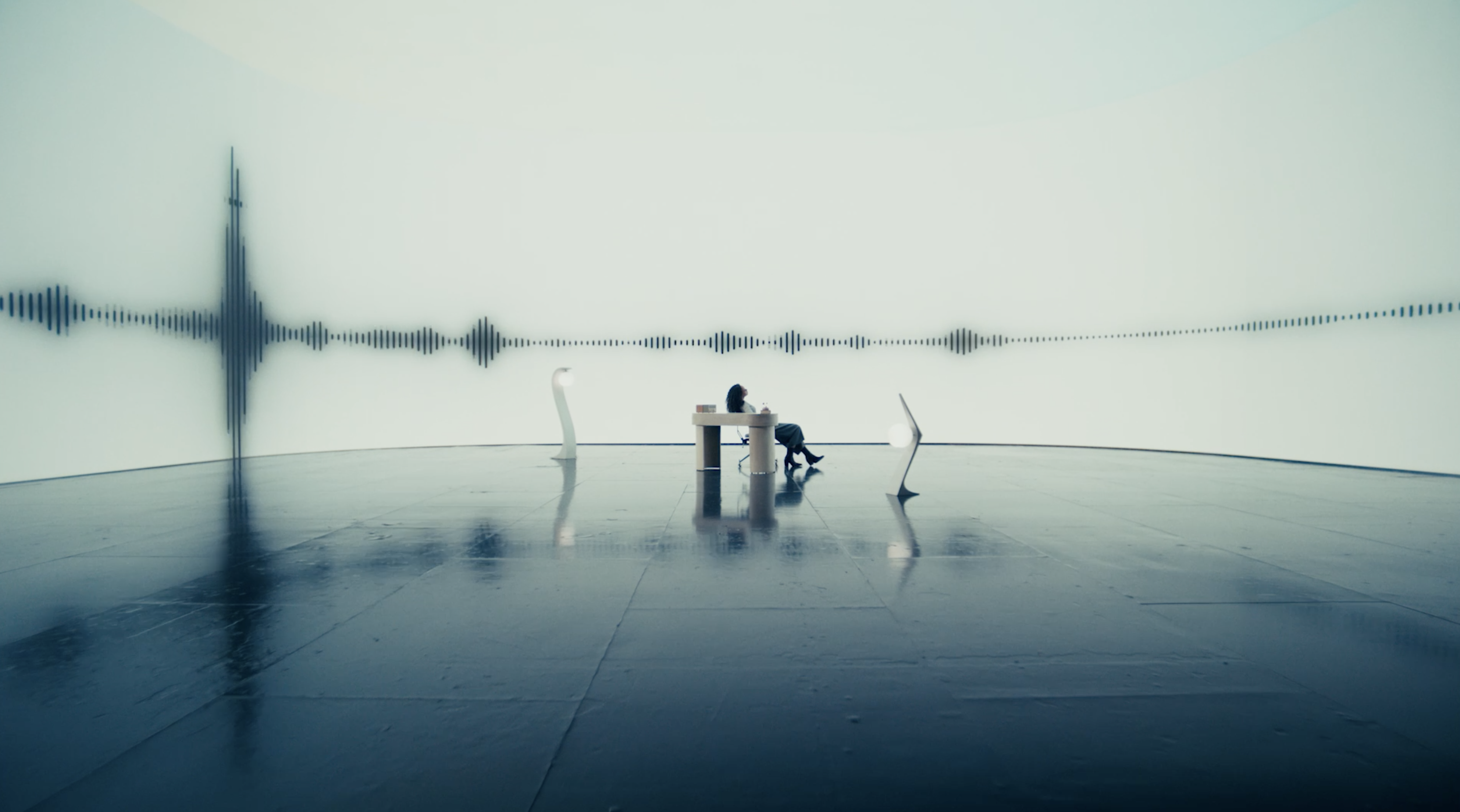 Woman at a desk with sound waves projected behind her