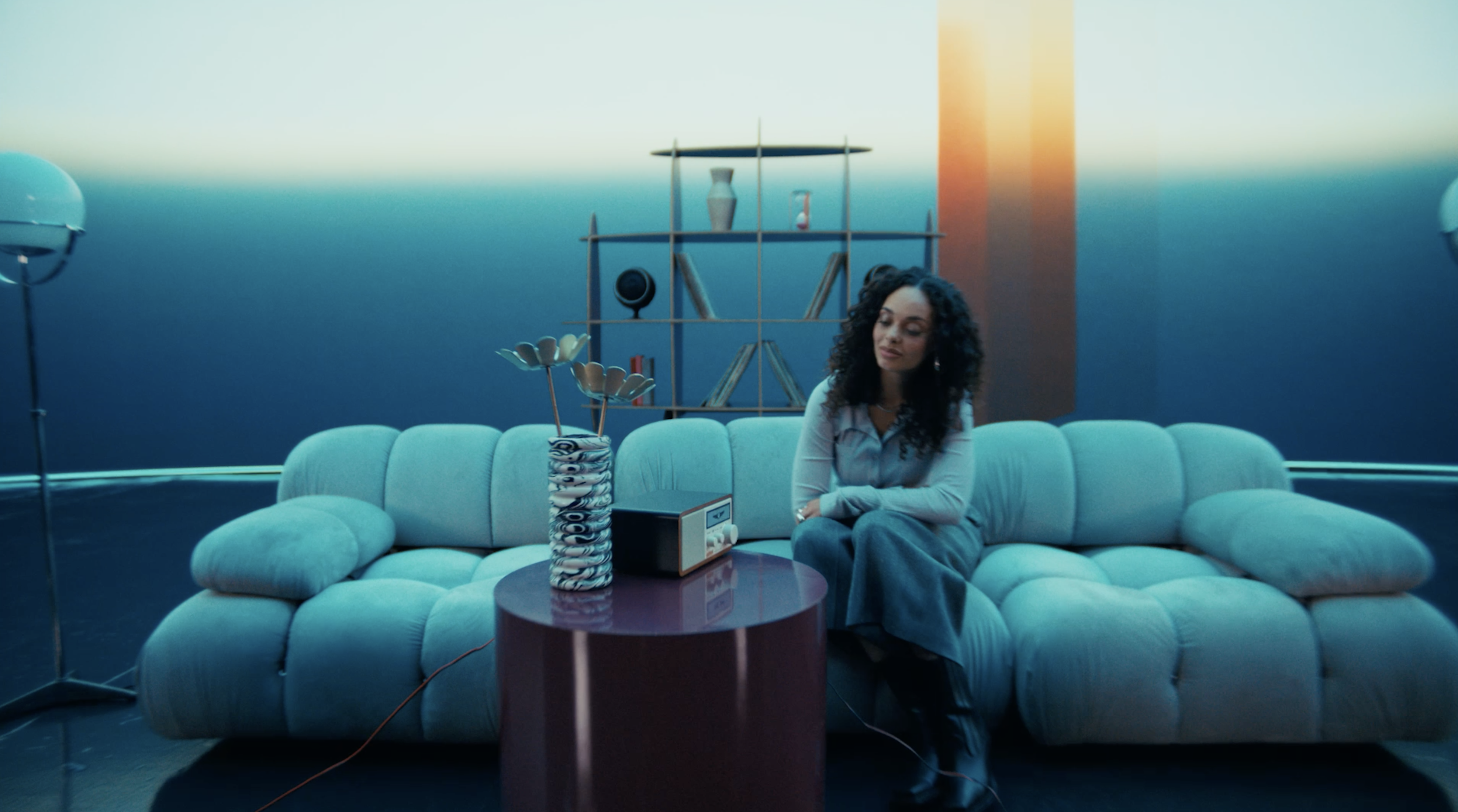 Woman on sofa looking at a radio. 