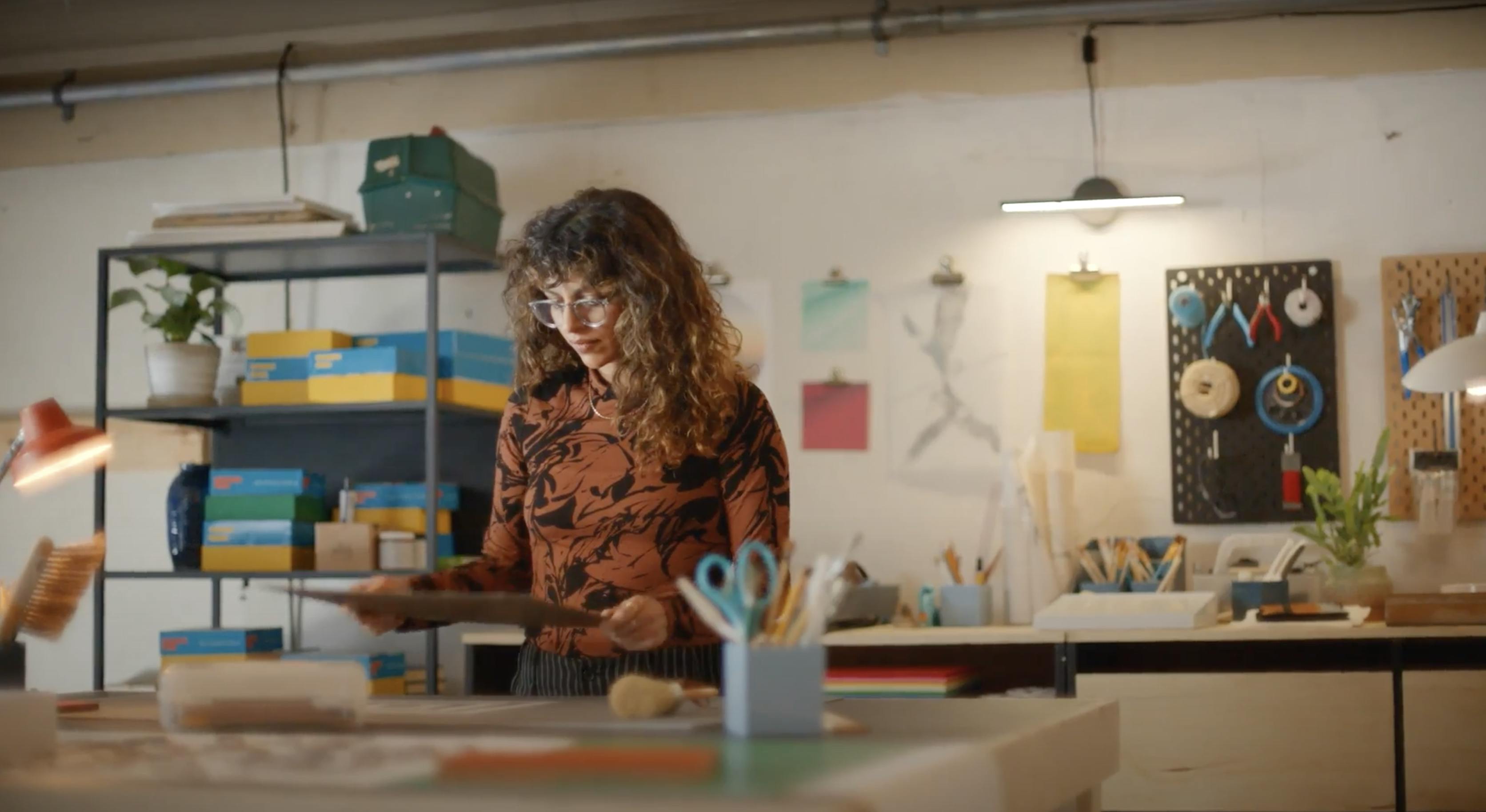 A woman in a creative studio looks at a board