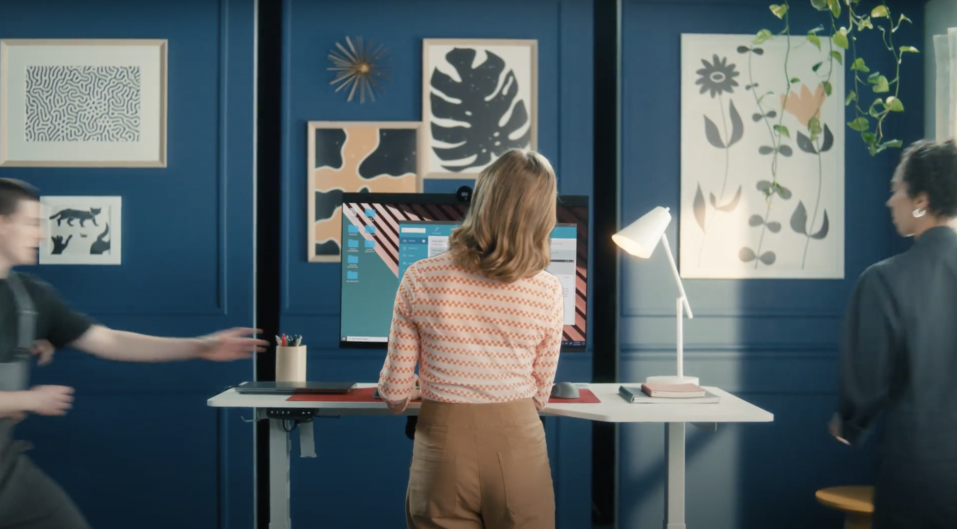 A woman in a blue room works at her computer
