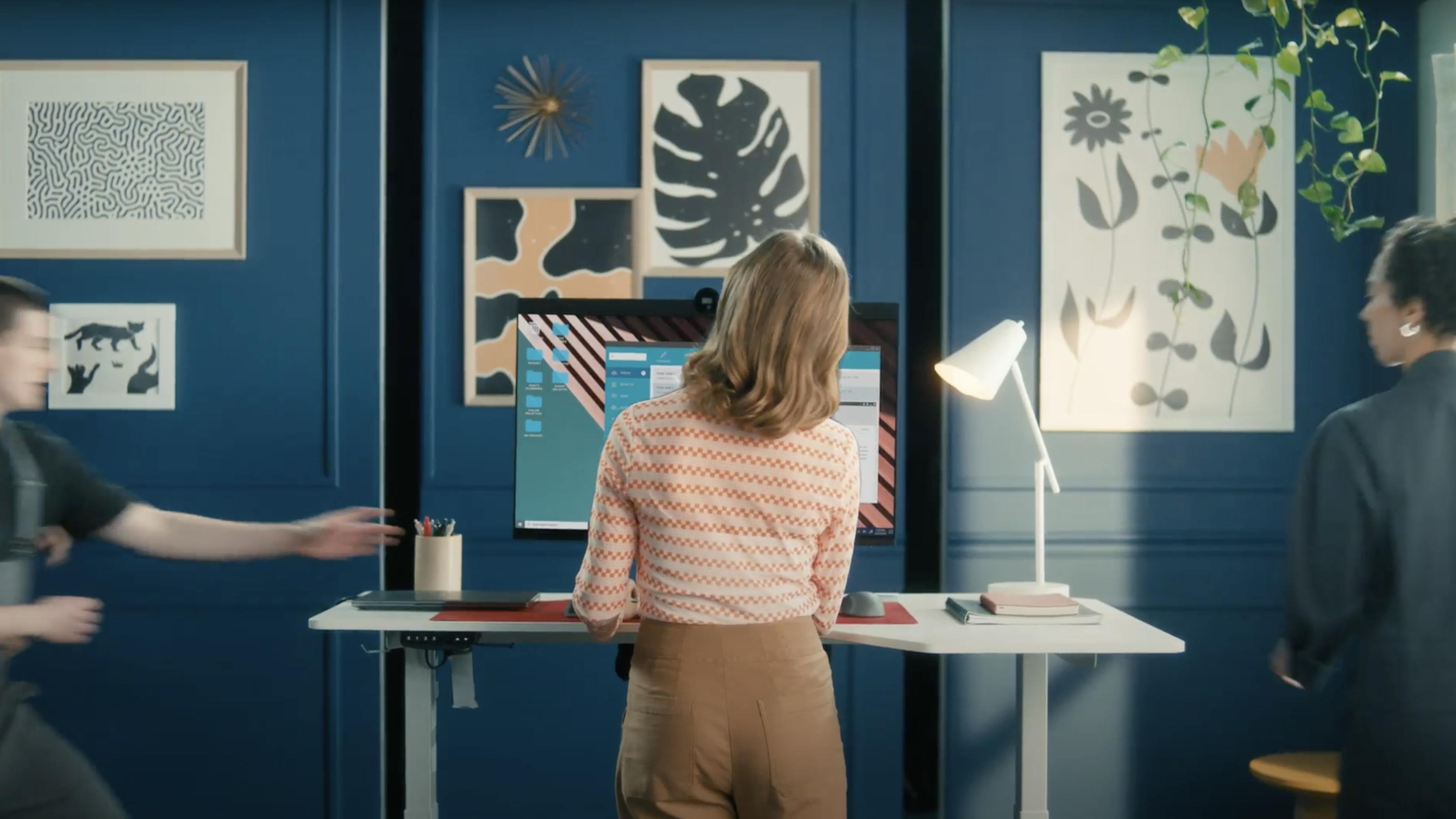 A woman in a blue room works at her computer