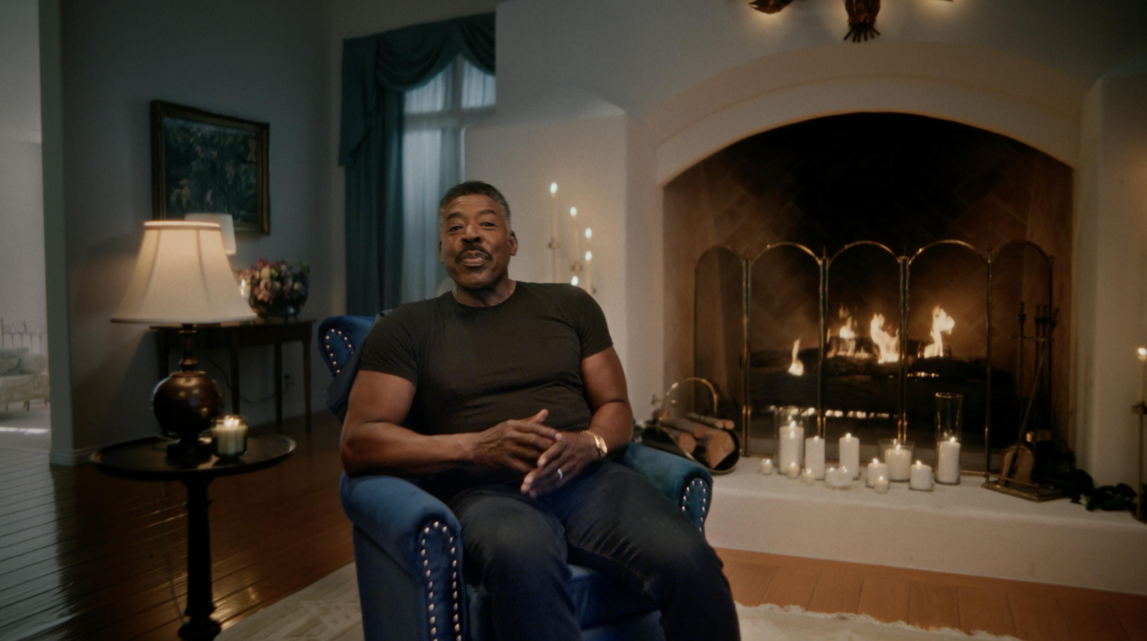 Ernie Hudson in a chair by fireplace