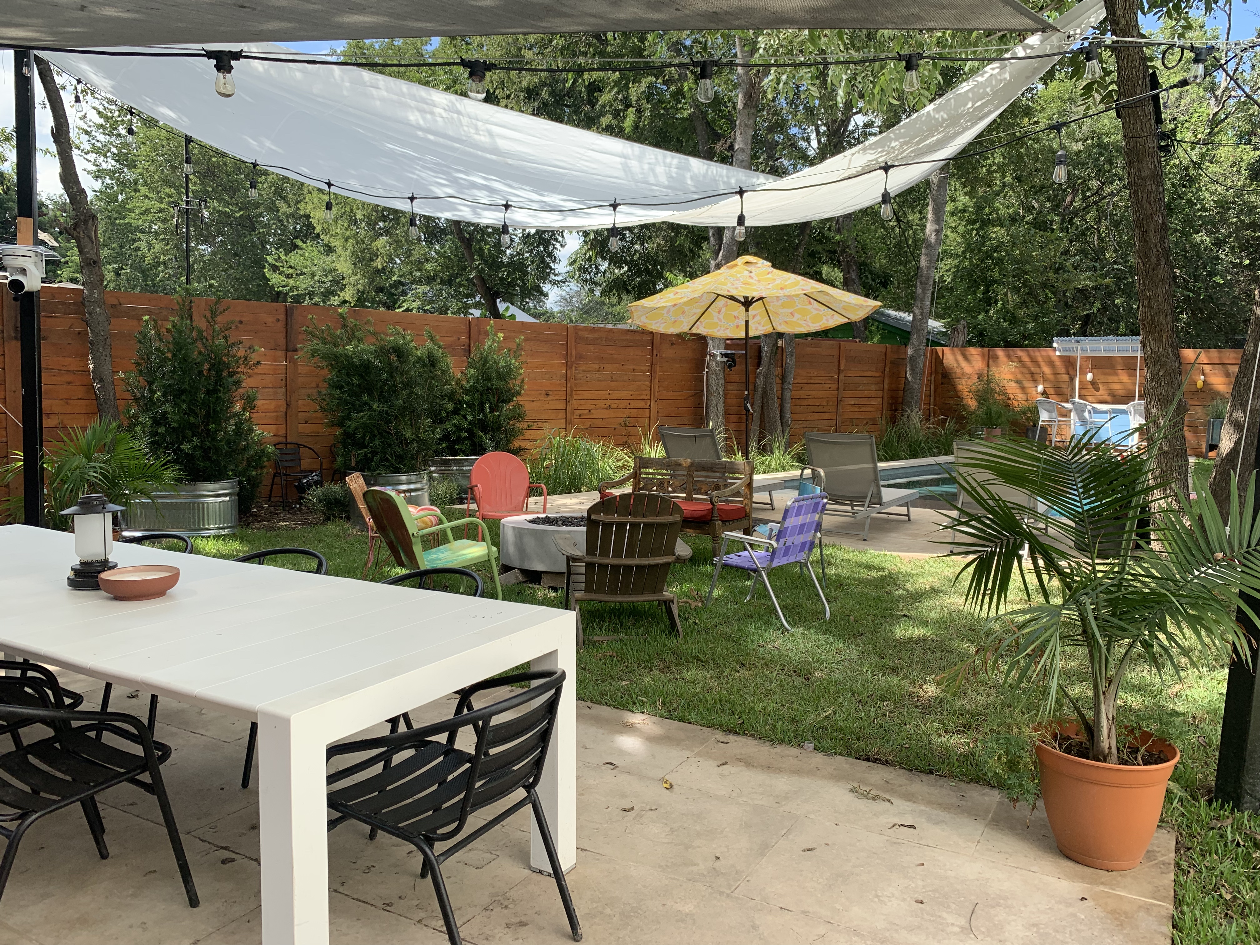 A backyard with communal seating and an outdoor table
