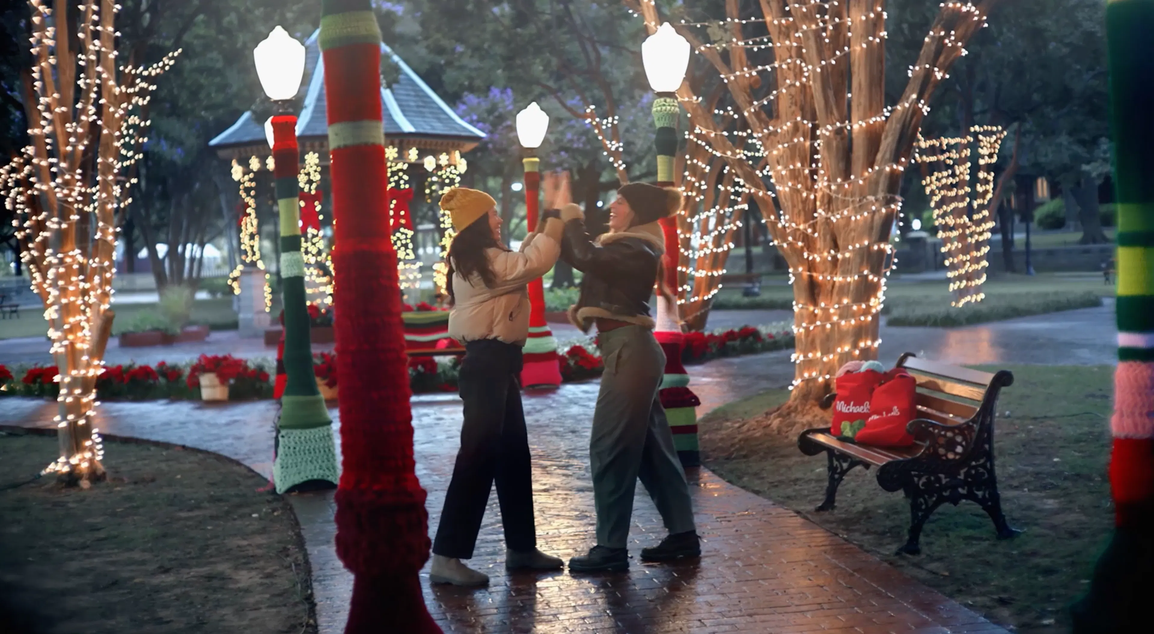 Two girls high five in a holiday decorated park