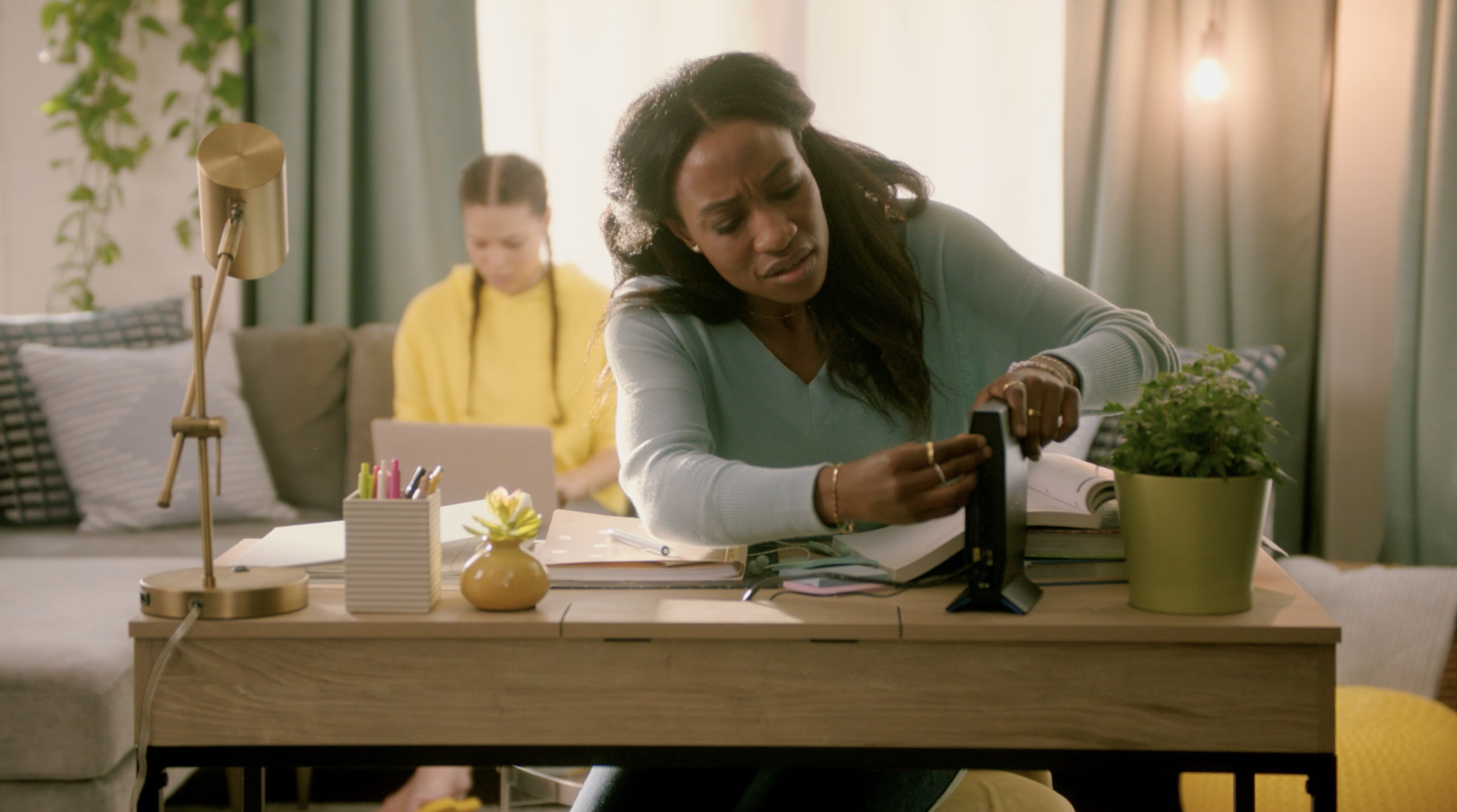 A woman resets the wifi router on her desk