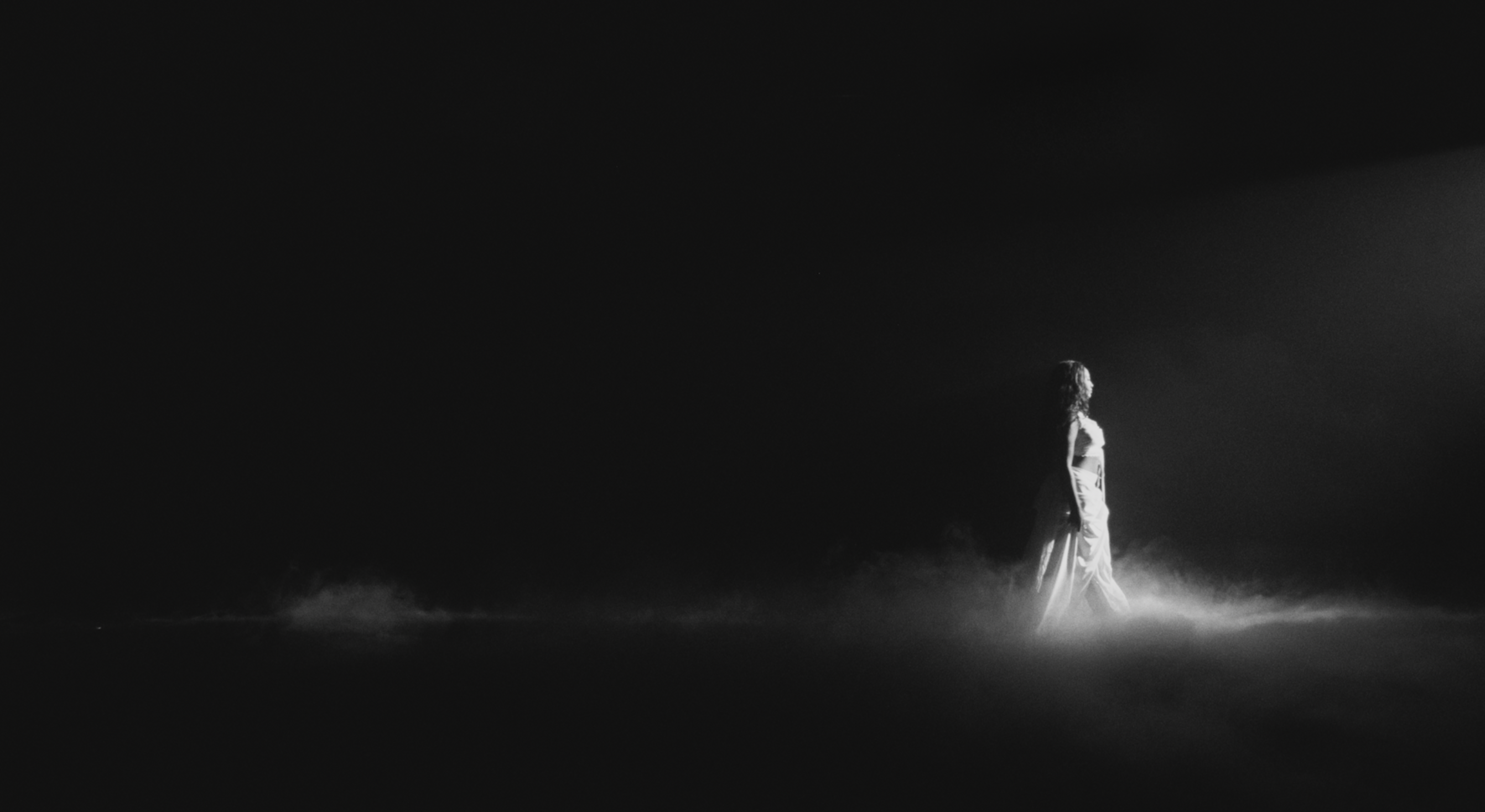 tems walking in black void with low fog
