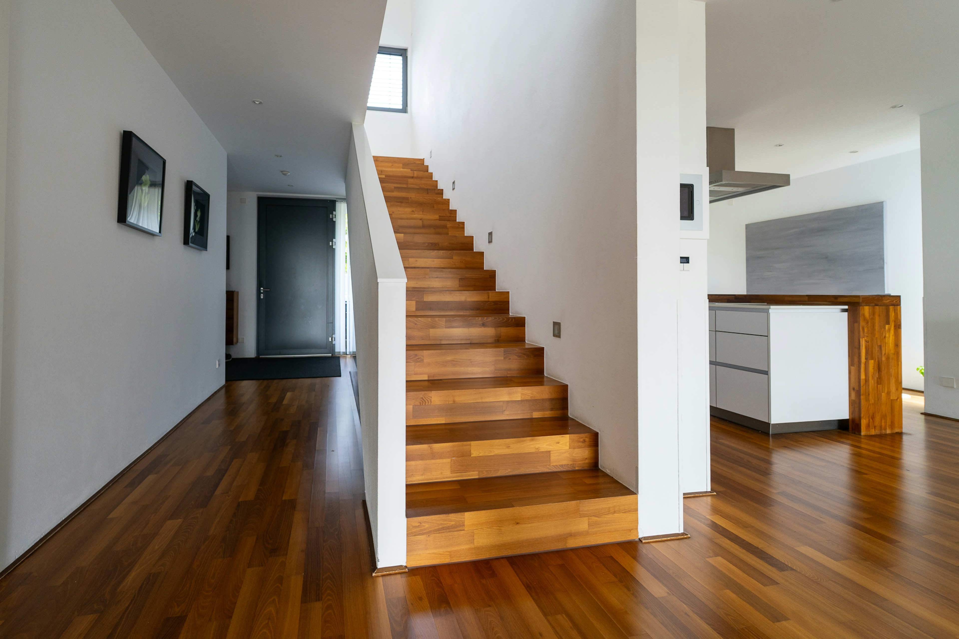 moderner Innenraum mit Holztreppe und offener Wohnküche
