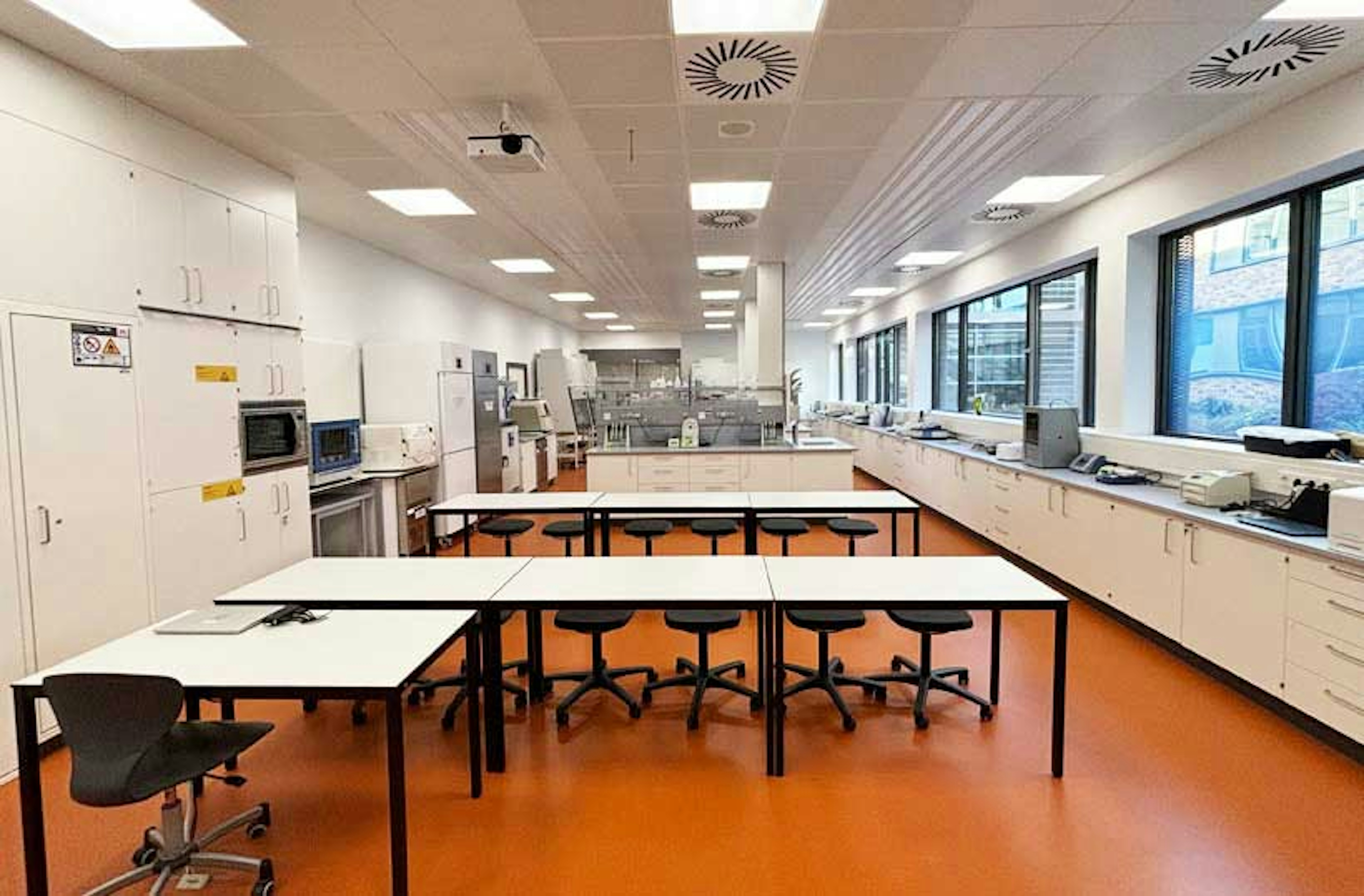 Heller Laborraum mit Tischgruppen, Drehhockern und moderner Lüftungsdecke in der Peter-Bruckmann-Schule Heilbronn.