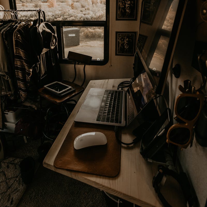 A close up shot of a keyboard and a mouse on a desk inside an RV.