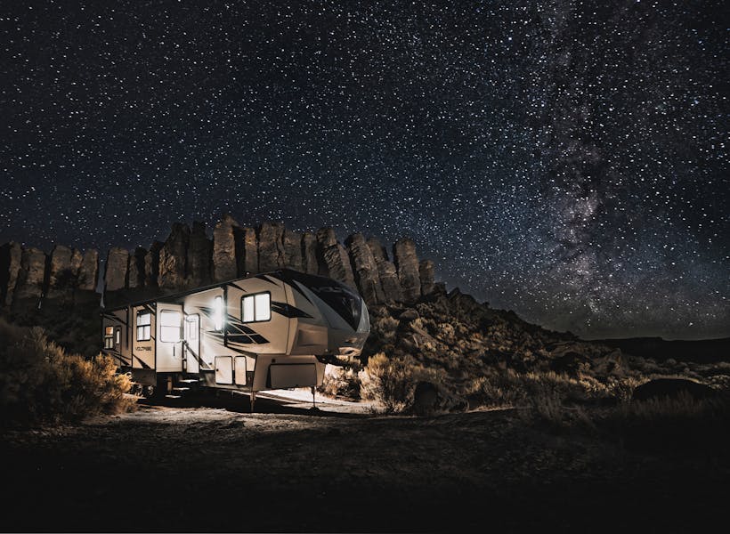 A Dutchmen fifth wheel RV under a starry sky