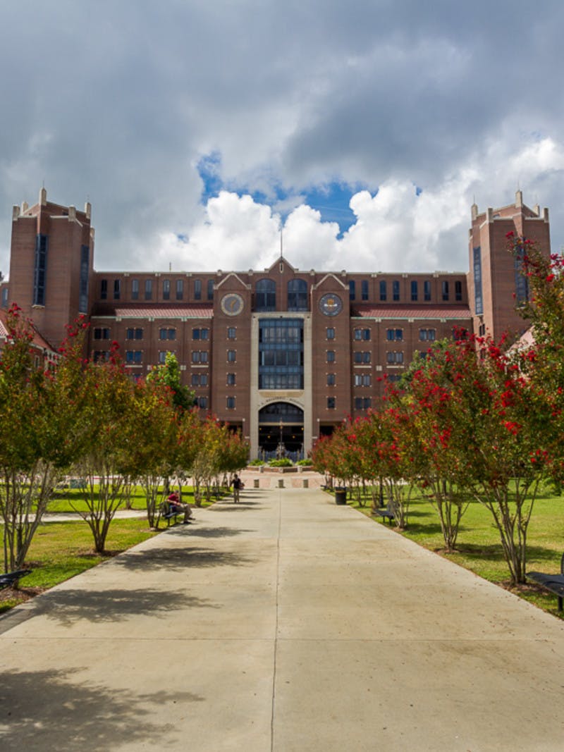 Tree-lined walkway to Doak S. Campbell Stadium brick building at Florida State University in Tallahassee, Florida.