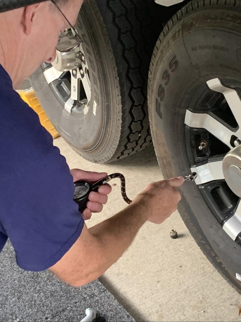 Tom Boswell showing how to check tire pressure on his RV.