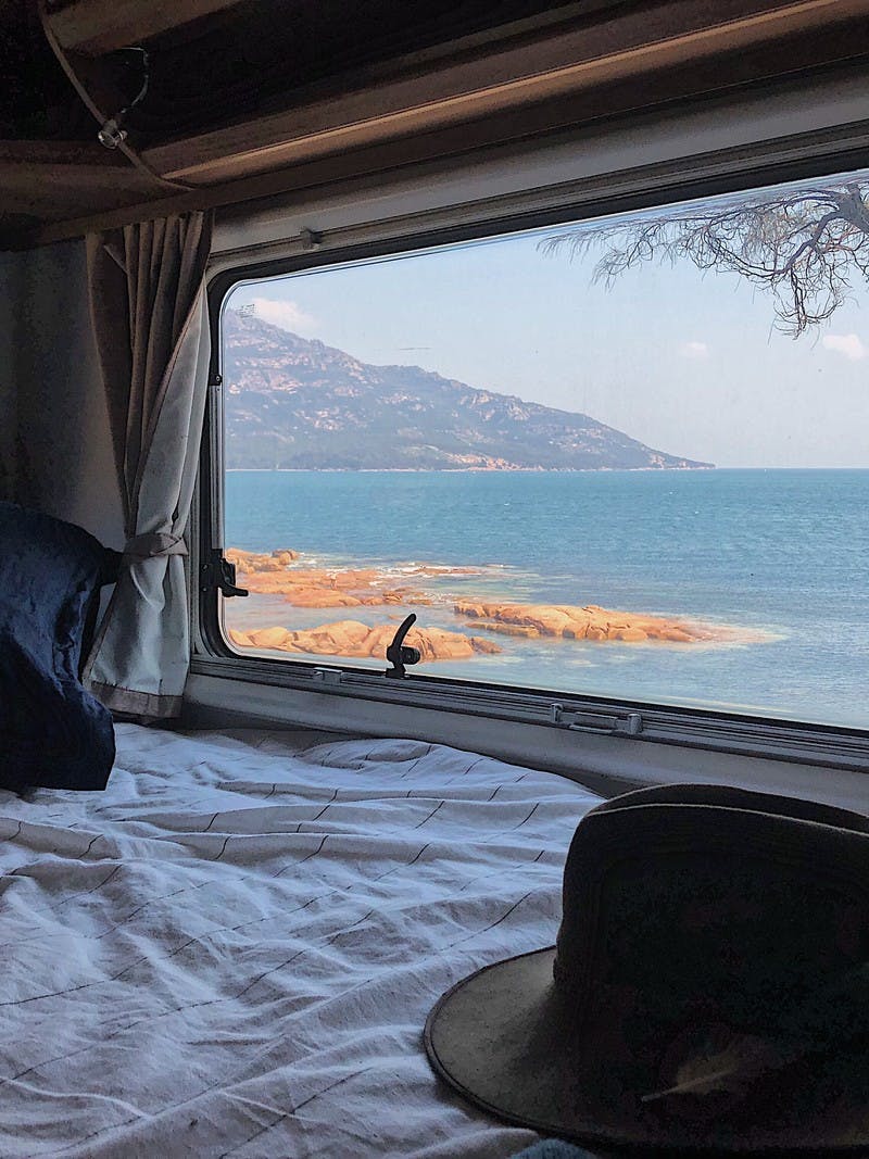 A view from the inside of an RV looking out the window to Coles Bay, in Tasmania, Australia.