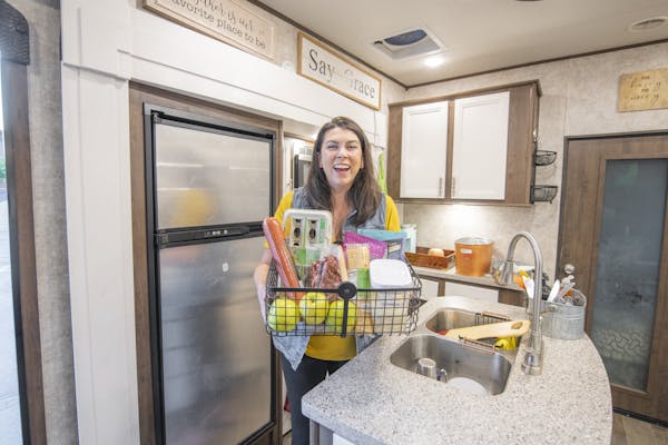 Chelsea Day holding a basket of food in the kitchen of her Highland Ridge RV