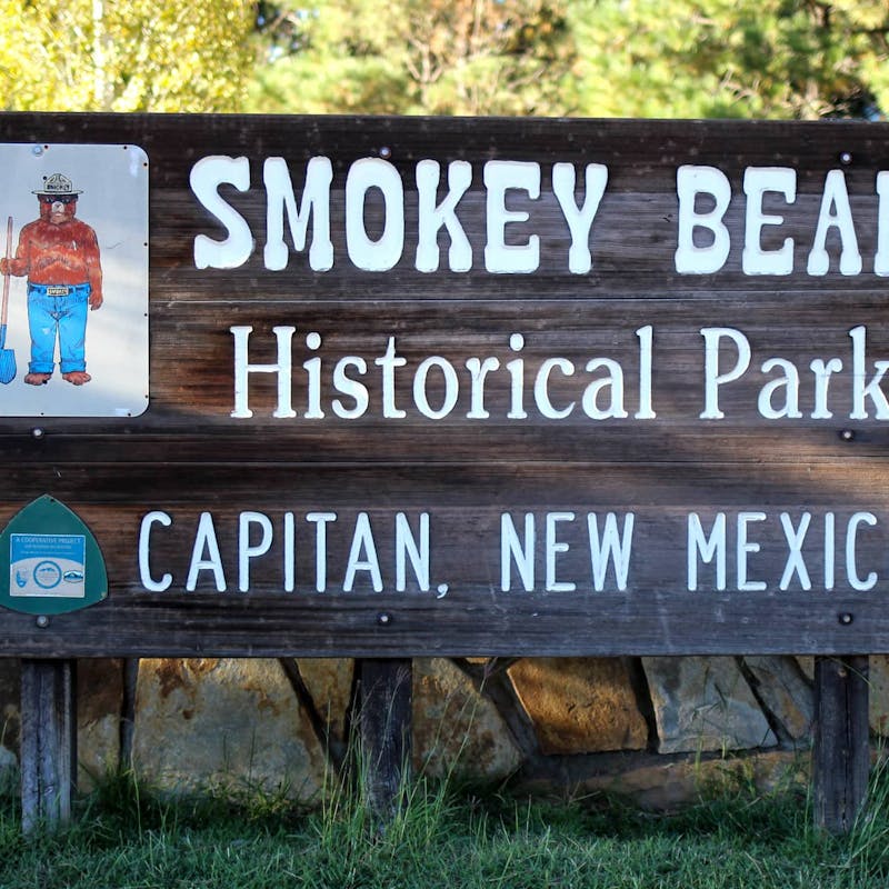 Dark wooden sign for Smokey Bear Historical Park in Capitan, New Mexico