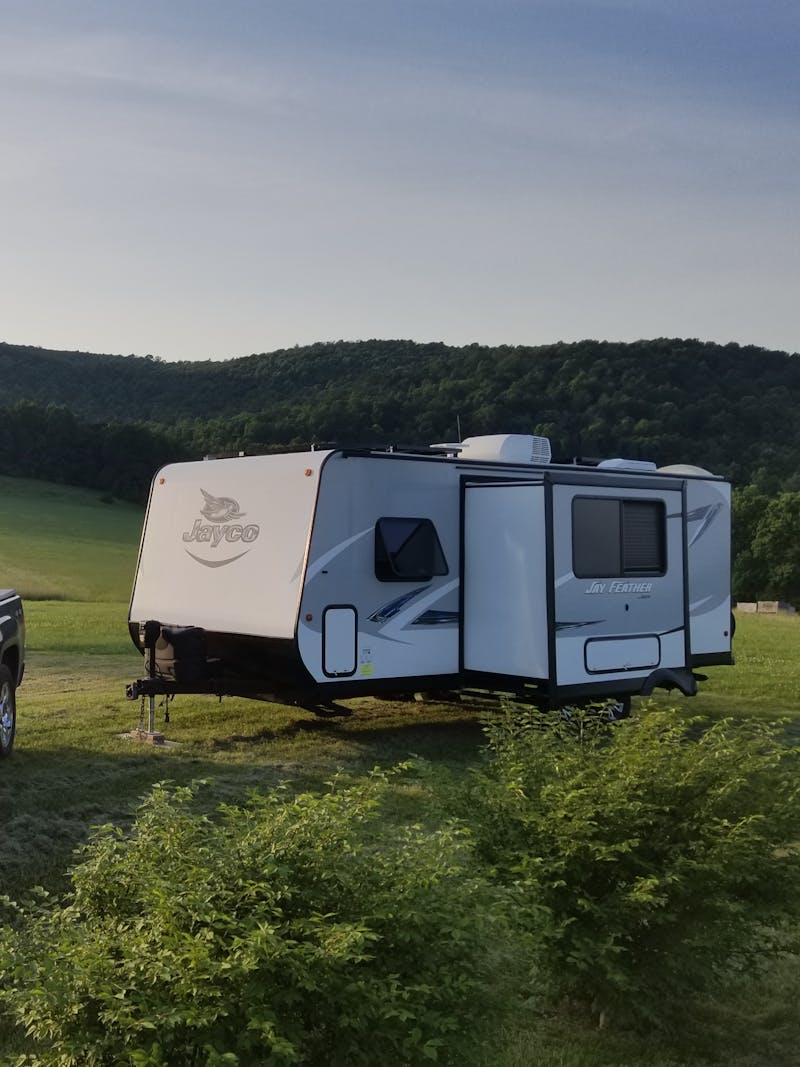 Ben and Christina McMillan's RV parked in a grassy field next to their truck