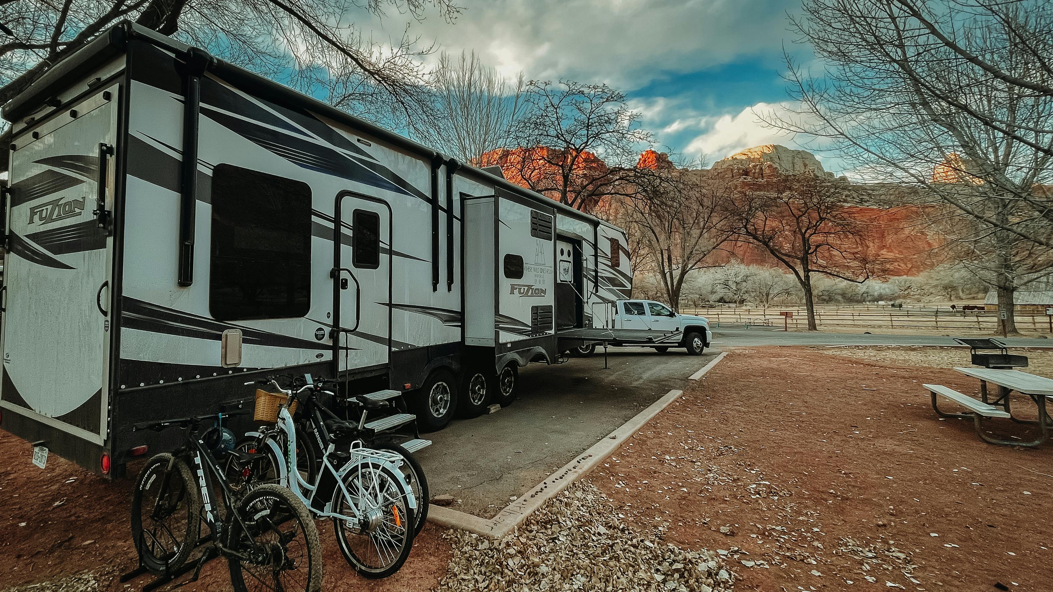 Andy and Kristen Murphy's Keystone Fuzion RV parked at a campsite with bikes leaning against the garage