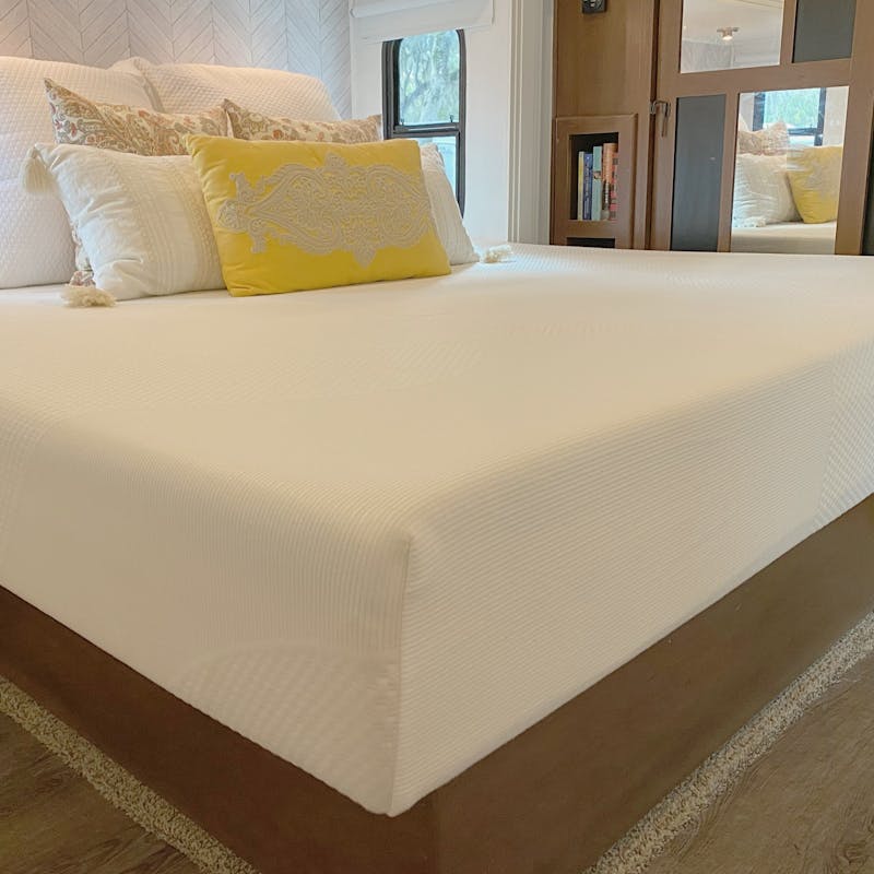 A king-sized memory foam mattress in an RV bedroom.