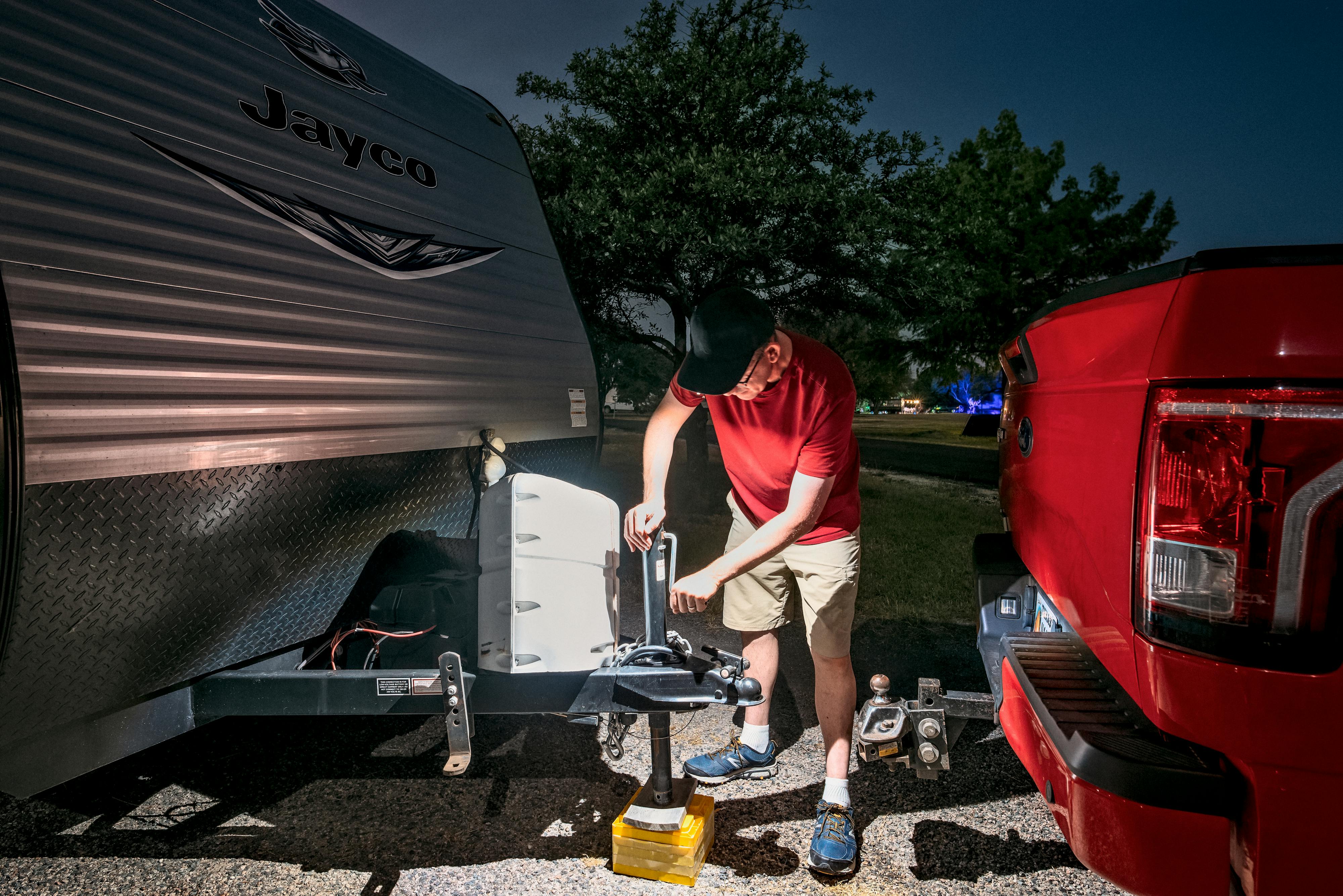 Jason Takacs unhitching his RV from his truck at night time