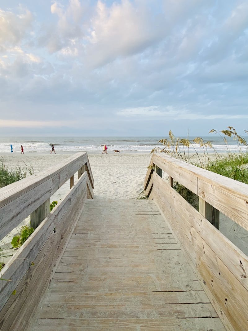 A photo of a boardwalk opening up to the beach.