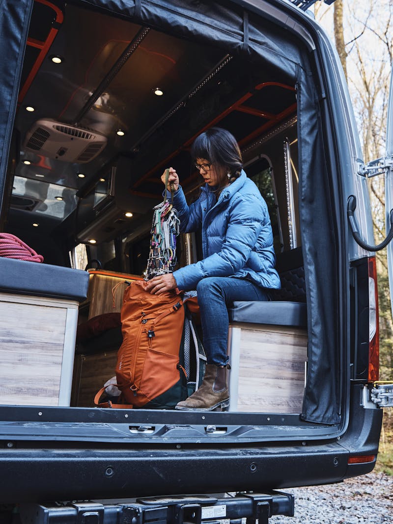 Kathy Karlo loads up climbing gear in the back of an Airstream camper van